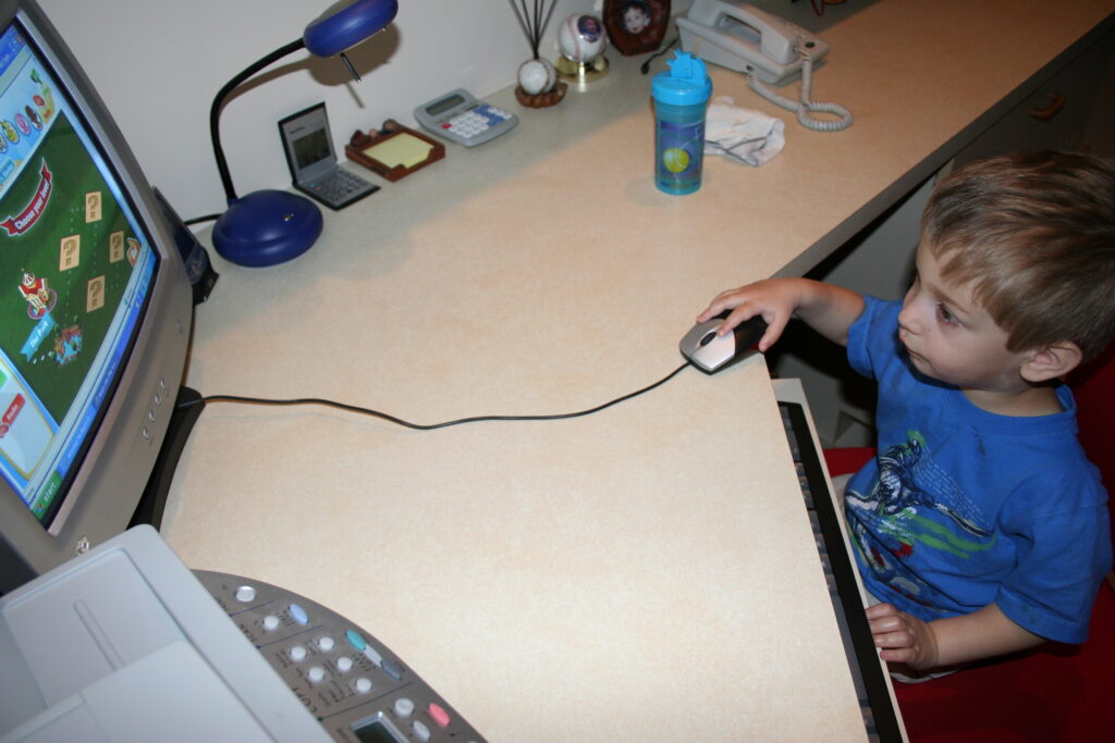 A picture of Nate as a small child using a computer.